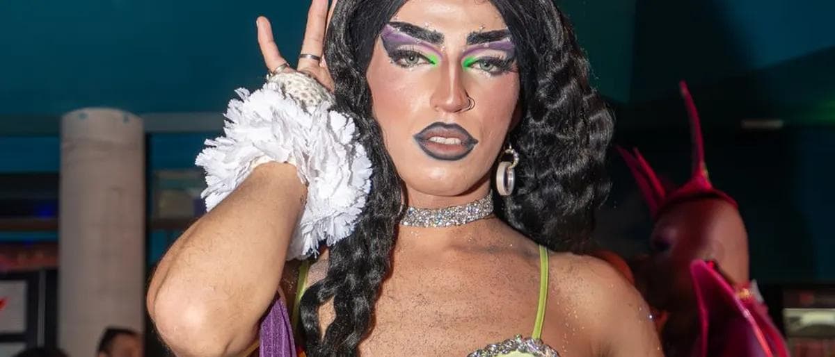 Drag performer in a green dress at a nightlife bar